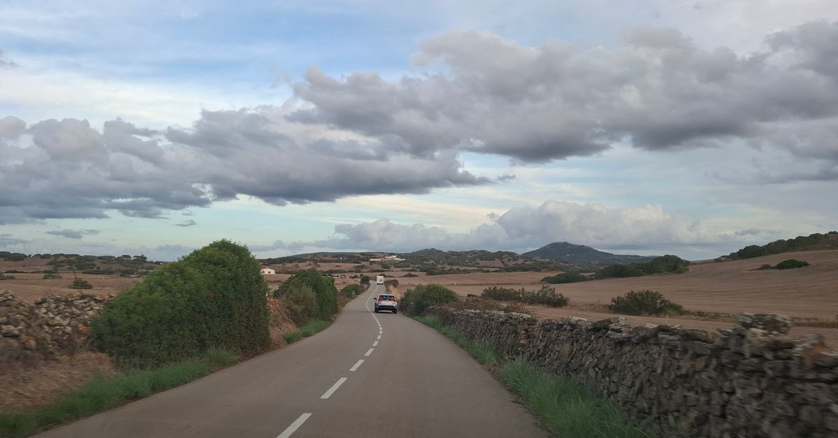 Car on a rural road through open countryside